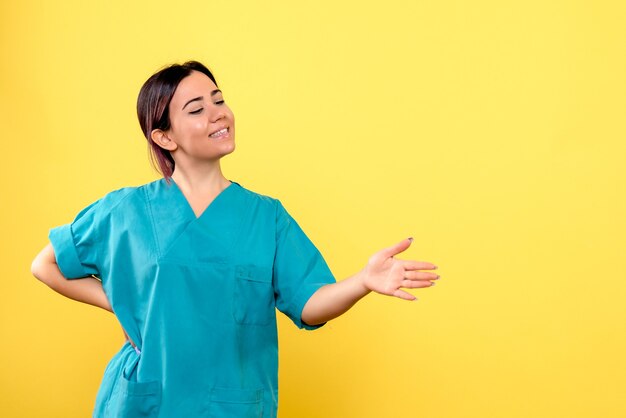 Vue latérale d'un médecin souriant médecin pointe sur le côté