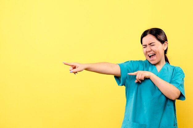 Vue latérale d'un médecin souriant médecin en uniforme heps les malades atteints du coronavirus