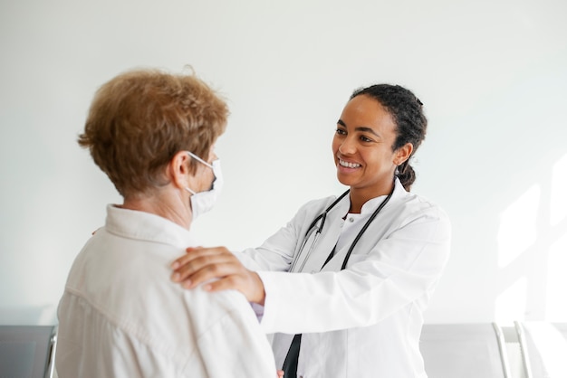 Vue latérale médecin souriant parlant au patient