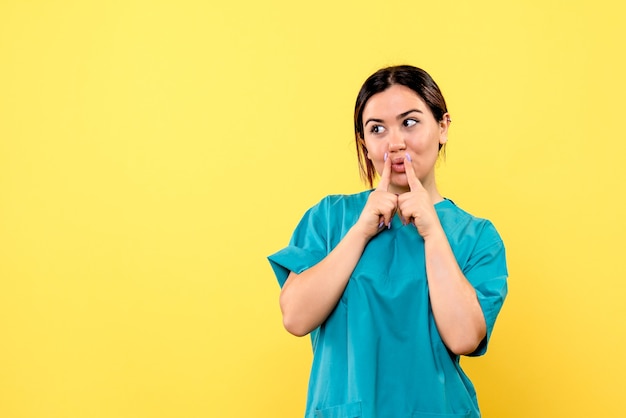 Vue latérale d'un médecin en uniforme explique comment aider les patients atteints de coronavirus