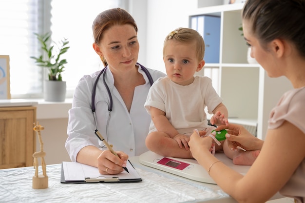 Vue latérale médecin vérifiant bébé