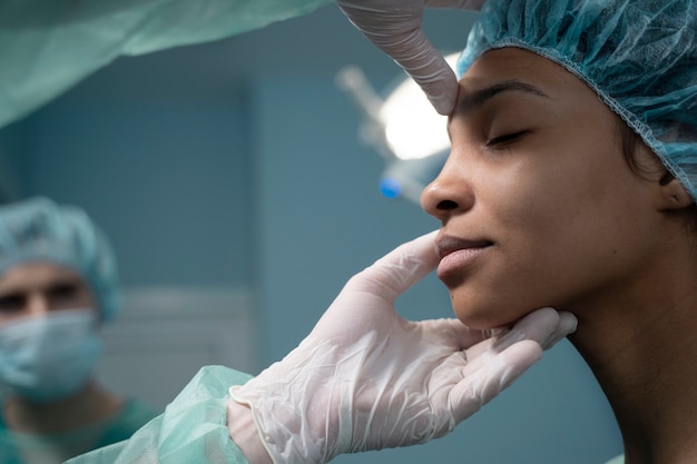 Vue latérale médecin vérifiant le patient avant la rhinoplastie