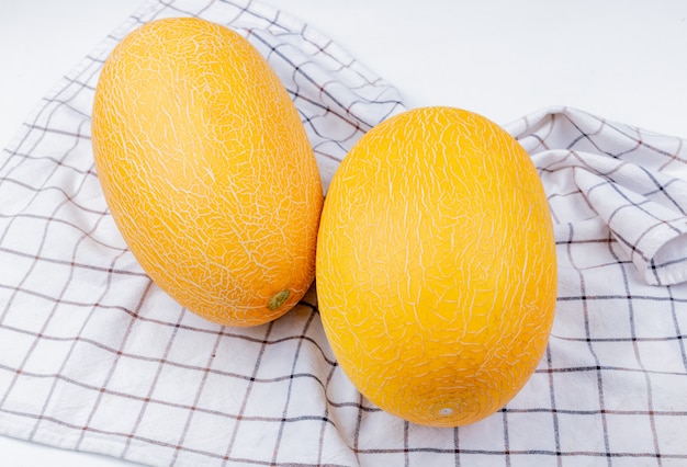 Vue latérale des melons sur fond de tissu à carreaux