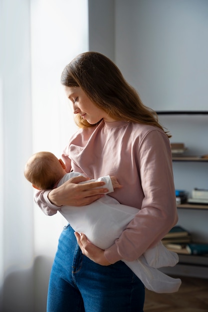 Vue latérale de la mère avec le mignon nouveau-né