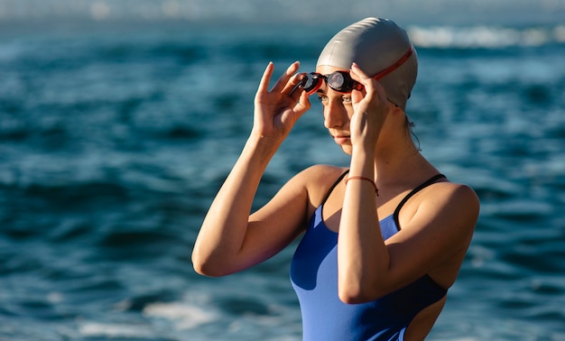 Vue latérale de la nageuse avec lunettes de natation et bonnet