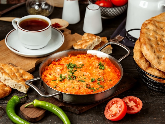 Photo gratuite vue latérale des œufs au plat avec tomate dans une casserole