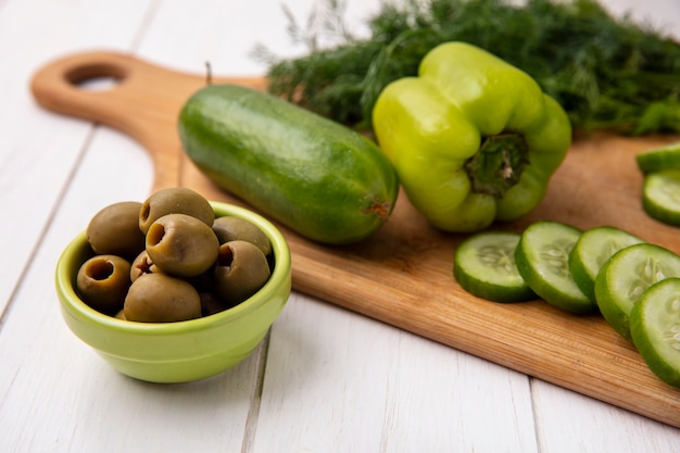 Vue latérale des olives au concombre poivron à l'aneth sur un support sur un fond blanc