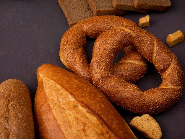 Vue latérale des pains comme bagel baguette de pain sandwich sur fond marron avec copie espace