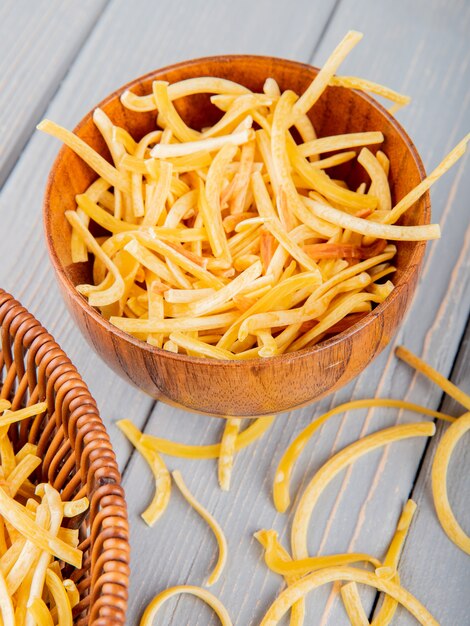 Vue latérale des pâtes crues italiennes traditionnelles faites maison dans un bol en bois rustique