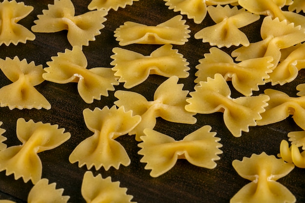 Photo gratuite vue latérale des pâtes crues sur une surface en bois