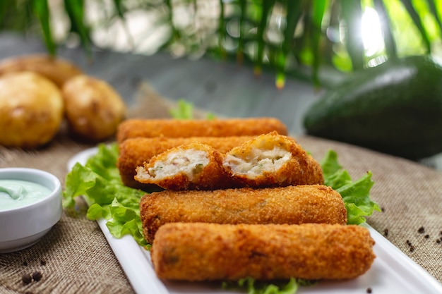 Vue latérale pépites de poulet sur des feuilles de laitue avec sauce