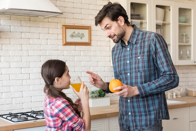 Vue latérale père enseignant fille sur les vitamines