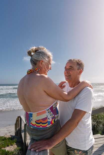 Photo gratuite vue latérale des personnes âgées heureuses à la plage