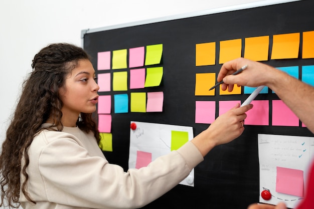 Vue latérale des personnes discutant avec post its