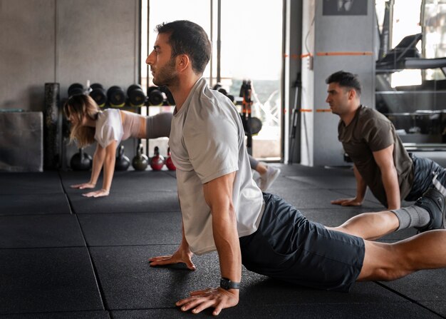 Vue latérale des personnes s'entraînant ensemble au gymnase