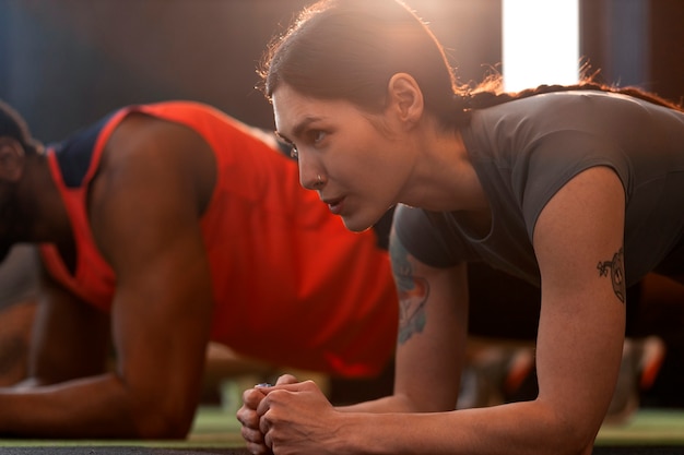 Vue latérale des personnes s'entraînant ensemble au gymnase