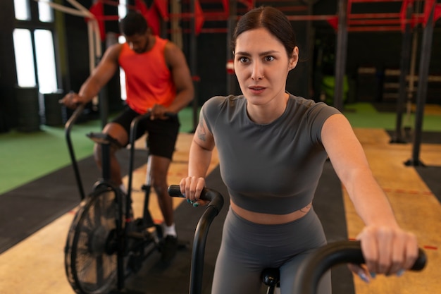 Photo gratuite vue latérale des personnes s'entraînant ensemble au gymnase