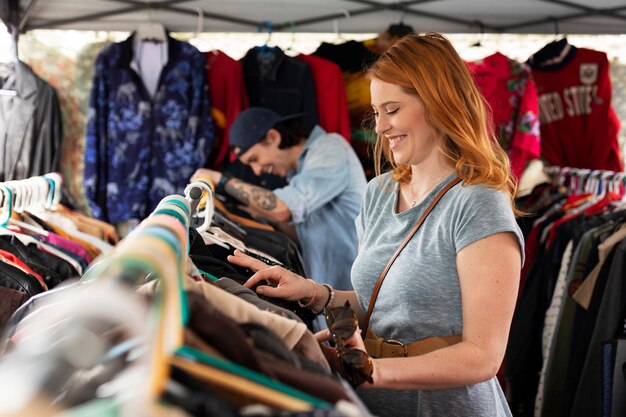 Vue latérale des personnes souriantes regardant des vêtements