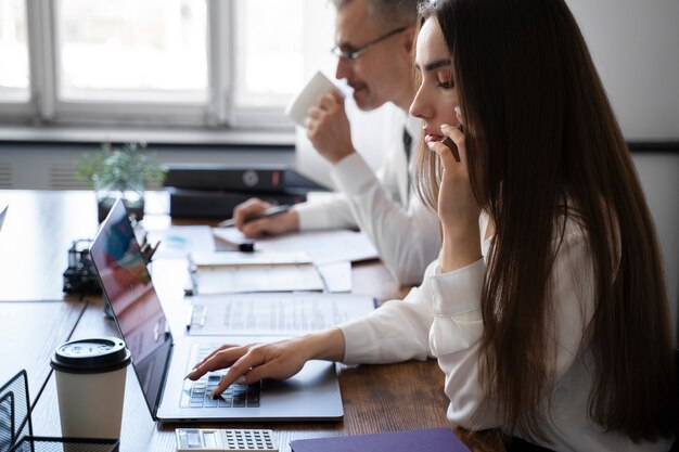 Vue latérale des personnes travaillant au bureau