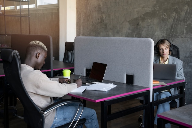 Vue latérale des personnes travaillant au bureau