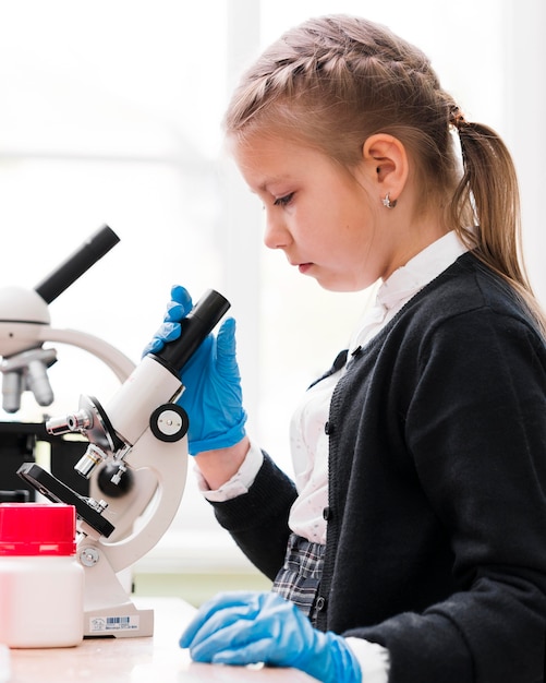 Vue latérale petite fille avec microscope