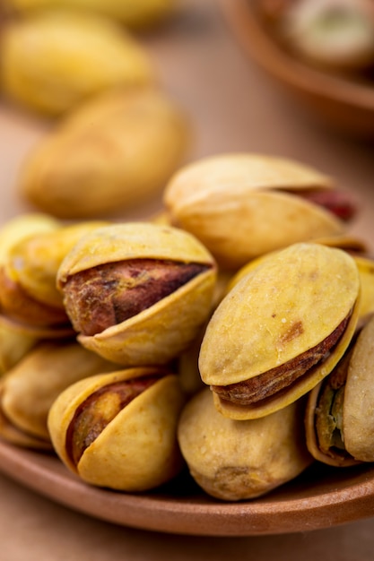 Vue latérale des pistaches grillées salées sur une cuillère en bois