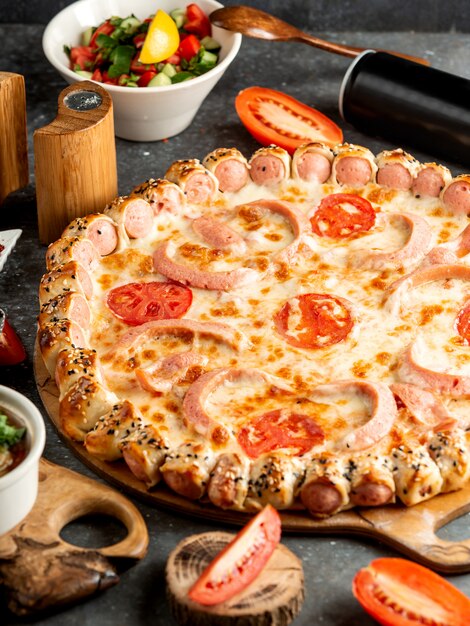 Vue latérale de pizza à la saucisse avec du fromage et de la tomate