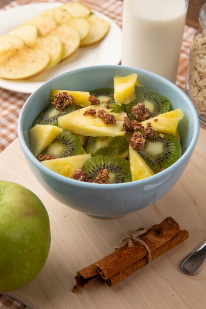 Vue latérale de la pomme en tranches sur une assiette avec une salade de fruits dans une assiette à la cannelle et à la pomme verte