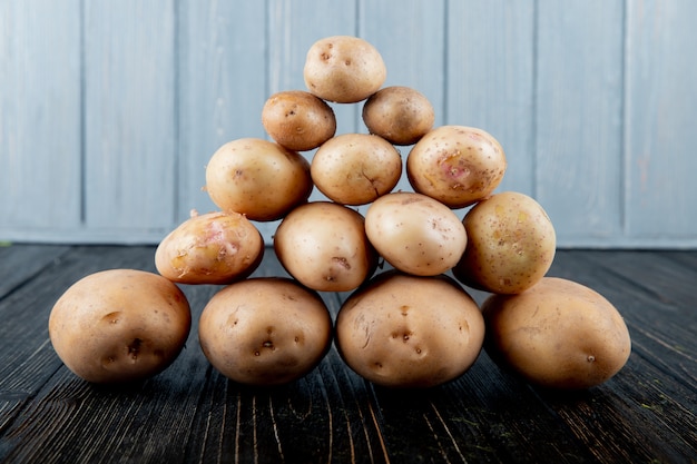 Vue latérale des pommes de terre en forme de pyramide sur la surface en bois et l'arrière-plan avec copie espace