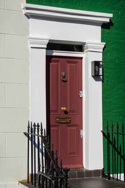 Vue latérale de la porte d'entrée avec mur beige et vert