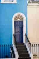 Photo gratuite vue latérale de la porte d'entrée avec mur bleu et beige