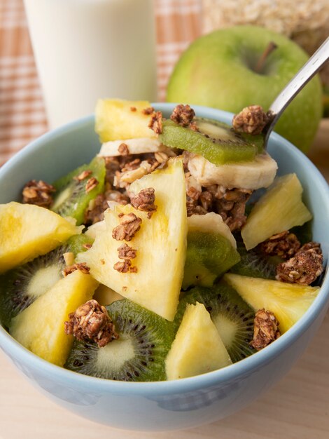 Vue latérale salade de fruits dans une assiette pomme verte ananas kiwi