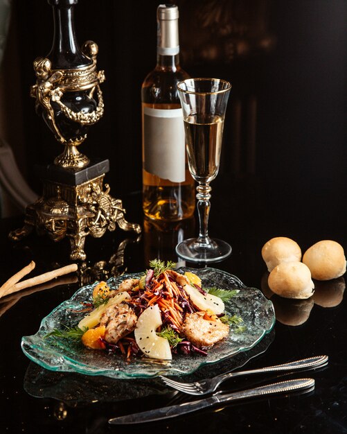 Vue latérale d'une salade de légumes hachés avec du poulet et de l'ananas sur une plaque sur la table