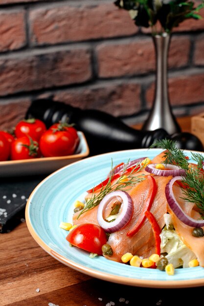 Vue latérale salade de poisson fumé rouge avec maïs oignons et tomates