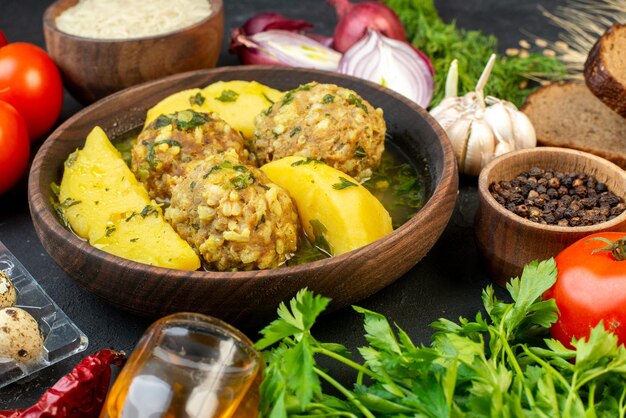 Vue latérale d'un savoureux repas de boulettes de viande tomates vertes tranches de pain ail sur fond noir