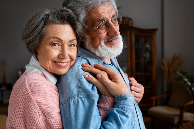 Vue latérale smiley couple de personnes âgées étreignant