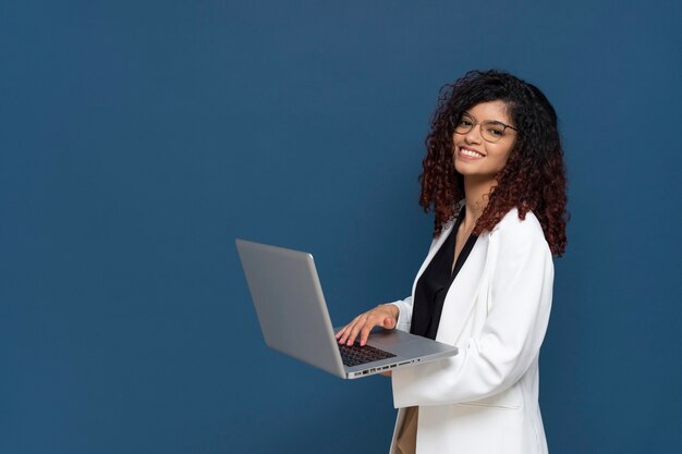 Vue latérale smiley femme d'affaires avec ordinateur portable