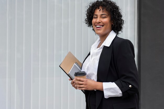 Vue latérale smiley femme d'affaires avec une tasse de café