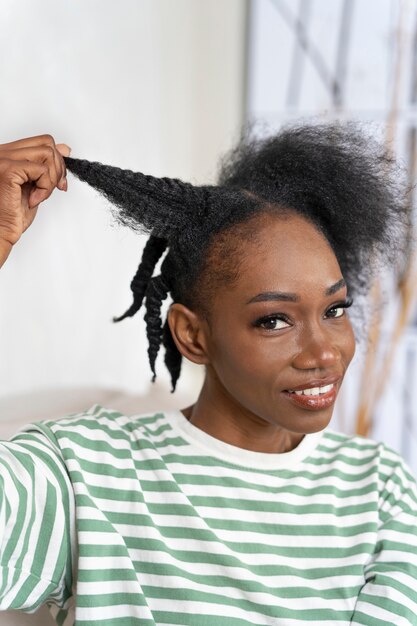 Vue latérale smiley femme coiffant les cheveux
