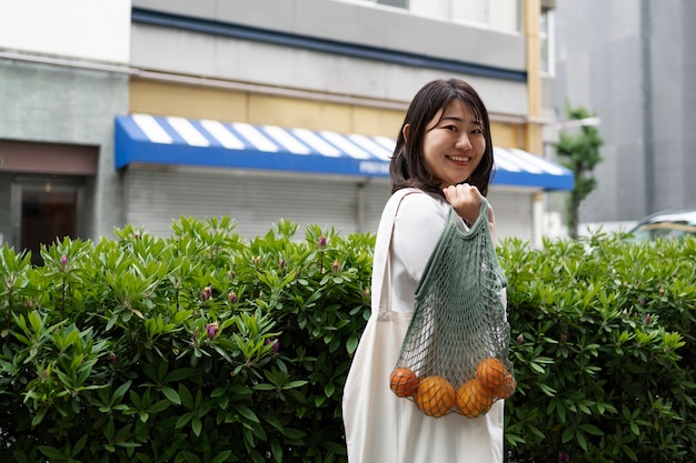 Vue latérale smiley femme portant des fruits