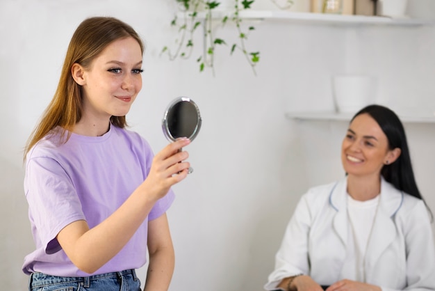 Vue latérale smiley femme regardant dans le miroir