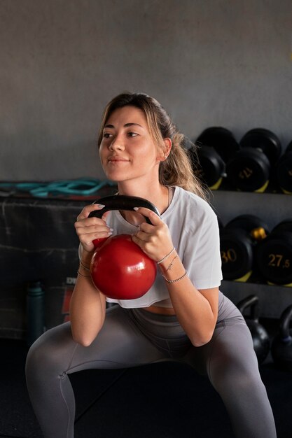 Vue latérale smiley femme s'entraînant au gymnase