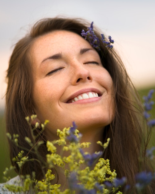 Vue latérale smiley femme tenant des fleurs