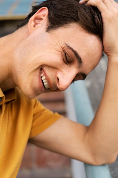 Vue latérale smiley homme posant à l'extérieur