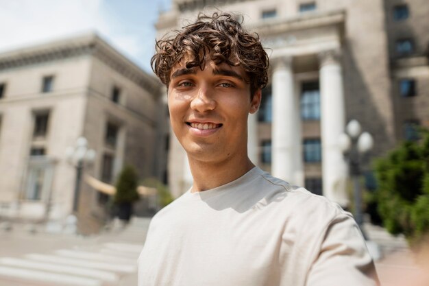 Vue latérale smiley homme prenant selfie à l'extérieur