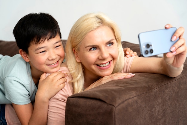 Vue latérale smiley mère et enfant sur le canapé