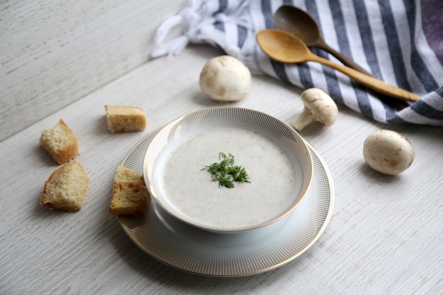 Vue latérale de la soupe à la crème de champignons dans un bol blanc