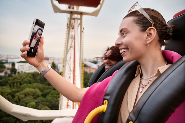 Photo gratuite vue latérale sourire y femme prenant selfie