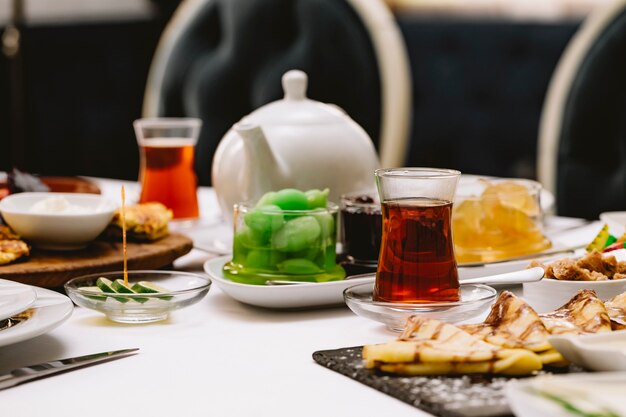 Vue latérale de la table servie avec du thé noir dans des verres armudu