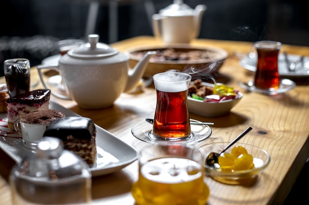 Vue latérale table de thé sucré avec un verre d'armudu de thé
